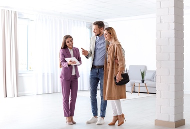 Female real estate agent working with couple in room