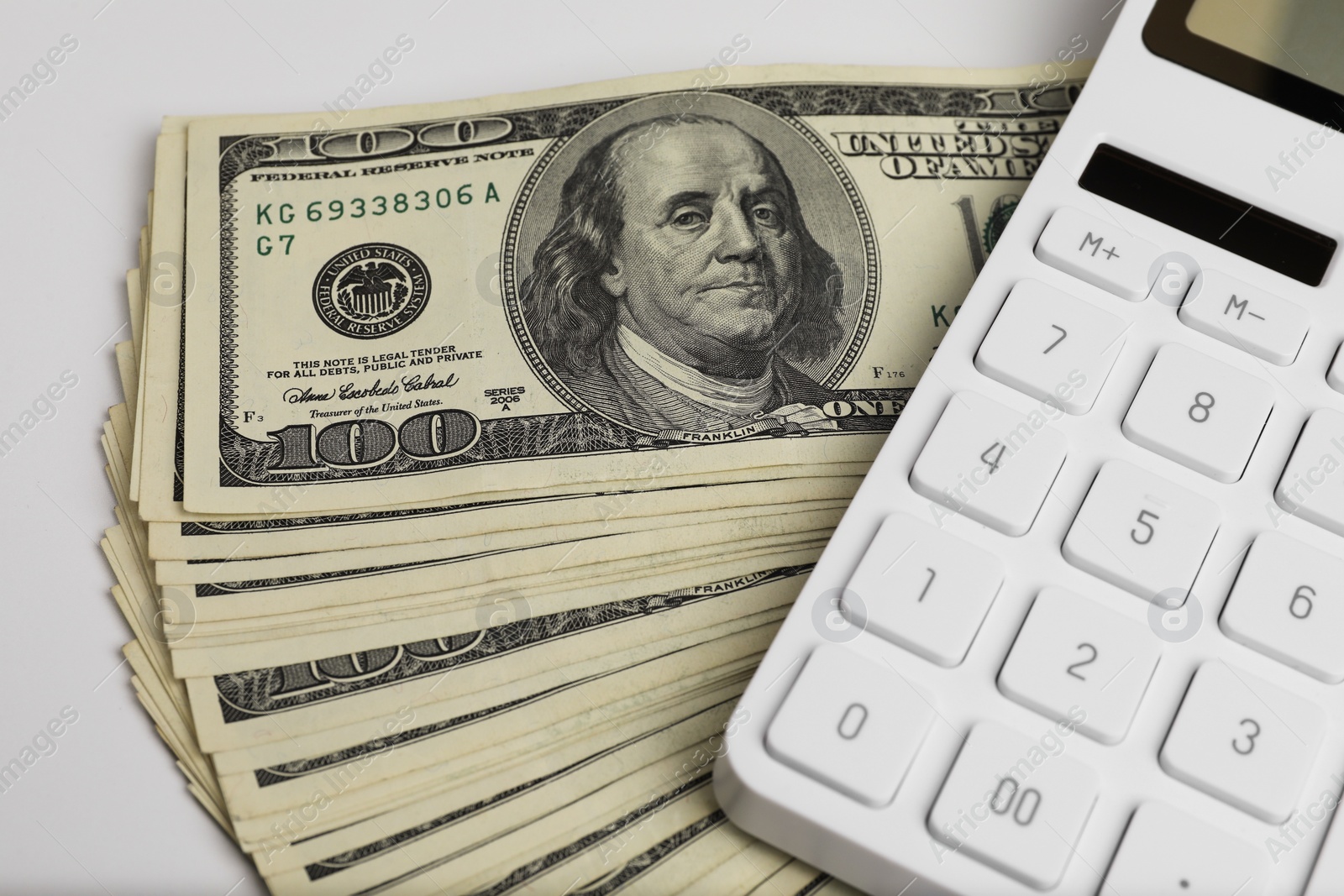 Photo of Money exchange. Dollar banknotes and calculator on white background, closeup