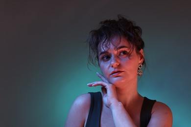 Portrait of beautiful woman on dark background with neon lights