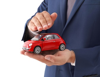 Insurance agent holding toy car on white background, closeup