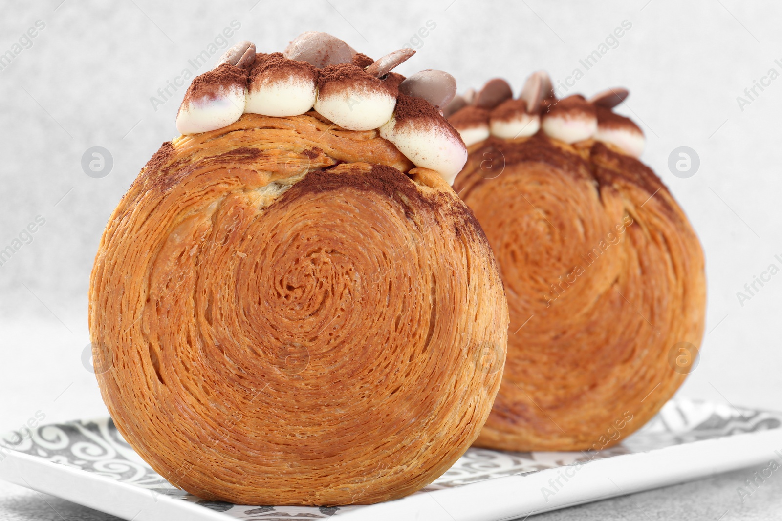 Photo of Supreme croissants with chocolate chips and cream on grey background, closeup. Tasty puff pastry