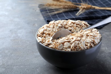 Photo of Oatmeal and spoon in bowl on grey table