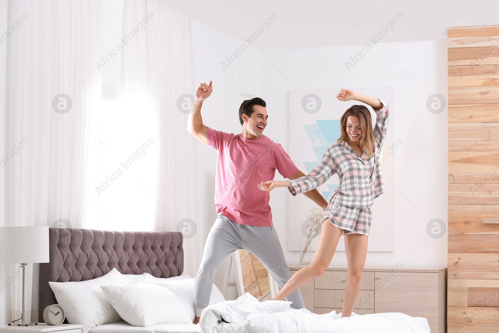 Photo of Beautiful young couple dancing in bedroom at home