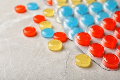 Photo of Color cough drops on light background, closeup