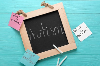 Photo of Chalkboard with word "Autism" and paper notes on wooden background