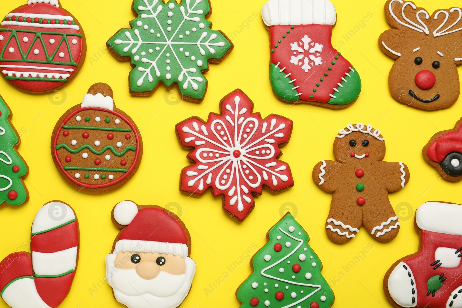 Photo of Different tasty Christmas cookies on yellow background, flat lay