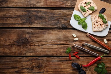 Photo of Flat lay composition with sandwiches, various spices and test tubes on wooden background. Space for text