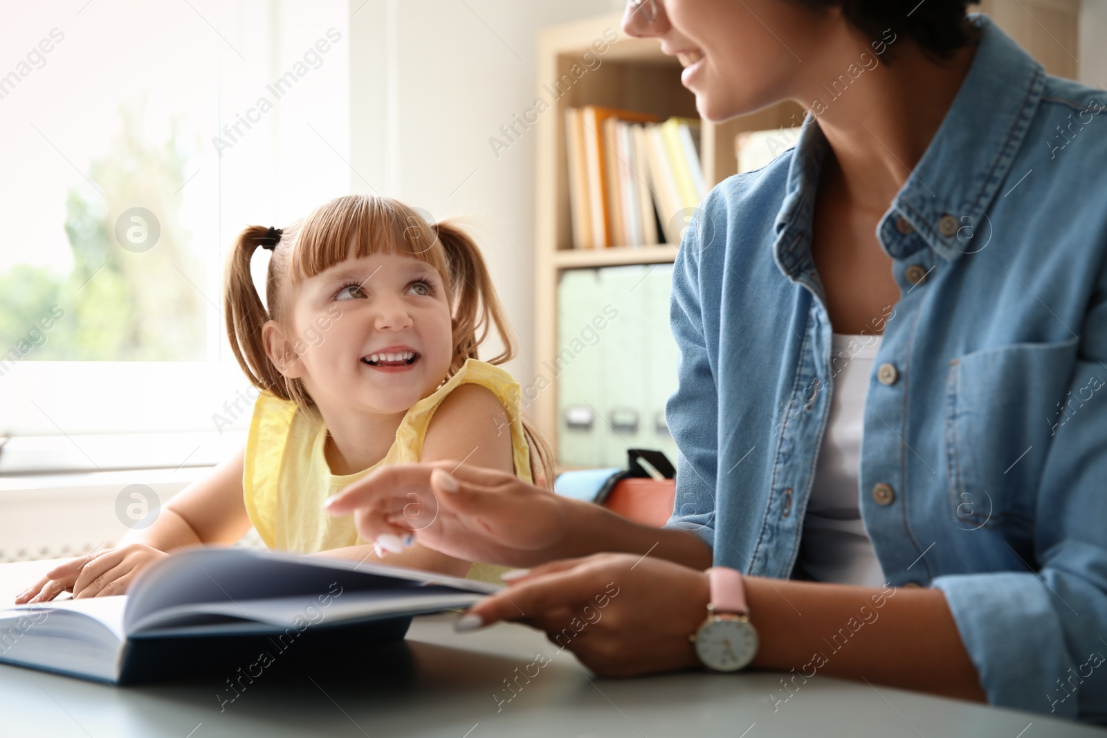Photo of Female teacher helping child with assignment at school