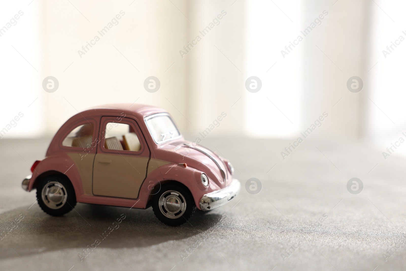 Photo of Toy car and on table against light background, space for text