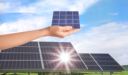 Woman demonstrating solar panel outdoors, closeup. Alternative energy source 