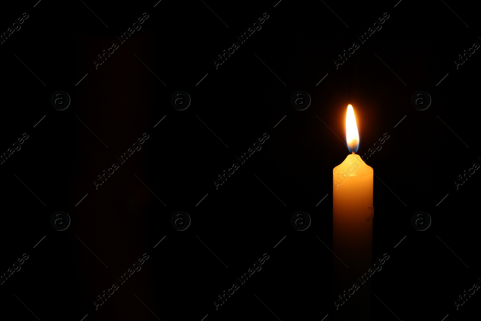 Photo of One burning candle on black background, space for text