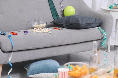 Photo of Living room interior with messy sofa. After party chaos