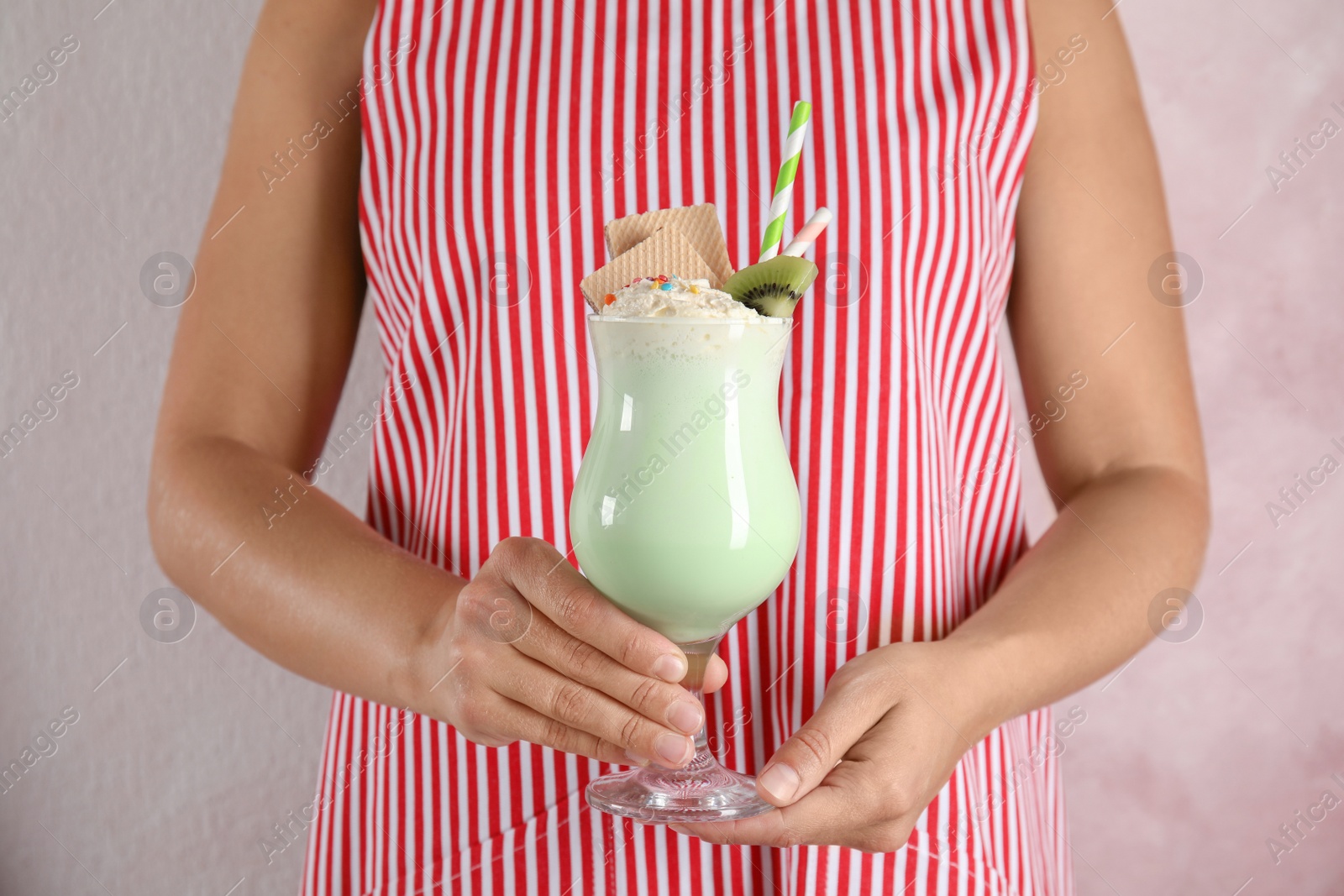 Photo of Woman with glass of delicious milk shake on color background, closeup