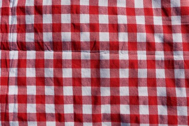 Red checkered picnic tablecloth as background, top view