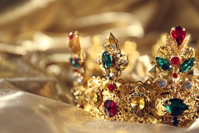 Beautiful ancient crown on golden fabric, closeup. Fantasy item