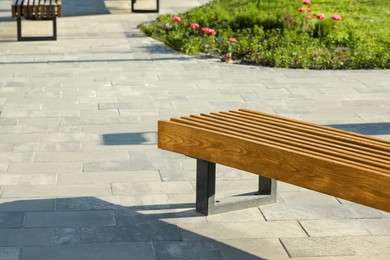 Photo of Wooden bench in city park on sunny morning