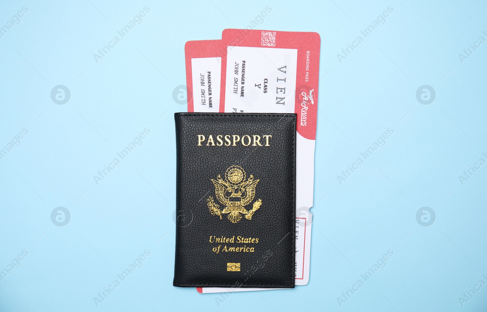 Photo of United States passport with tickets on light blue background, top view