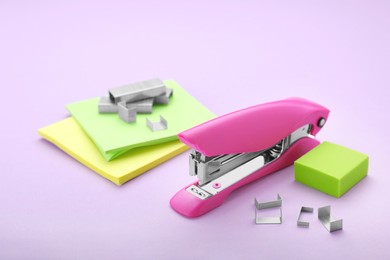Photo of New bright stapler with stationery on light grey background