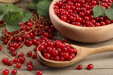 Ripe red currants and leaves on wooden table