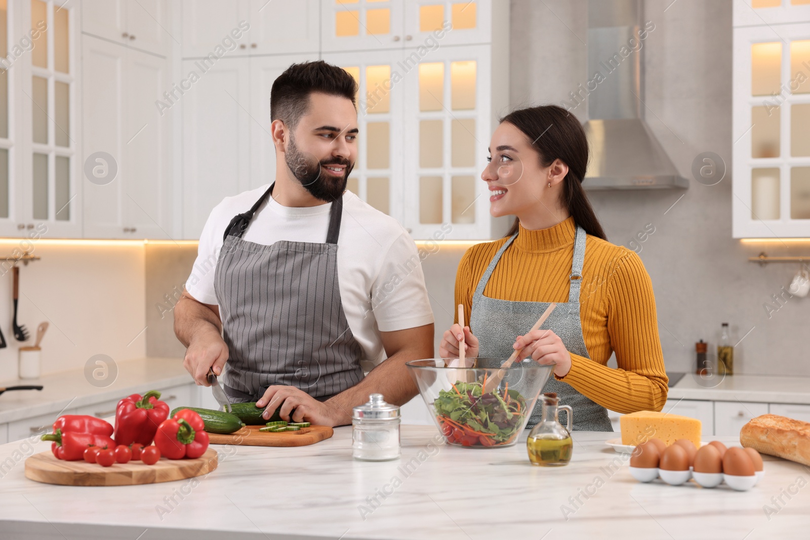 Photo of Lovely young couple cooking together in kitchen