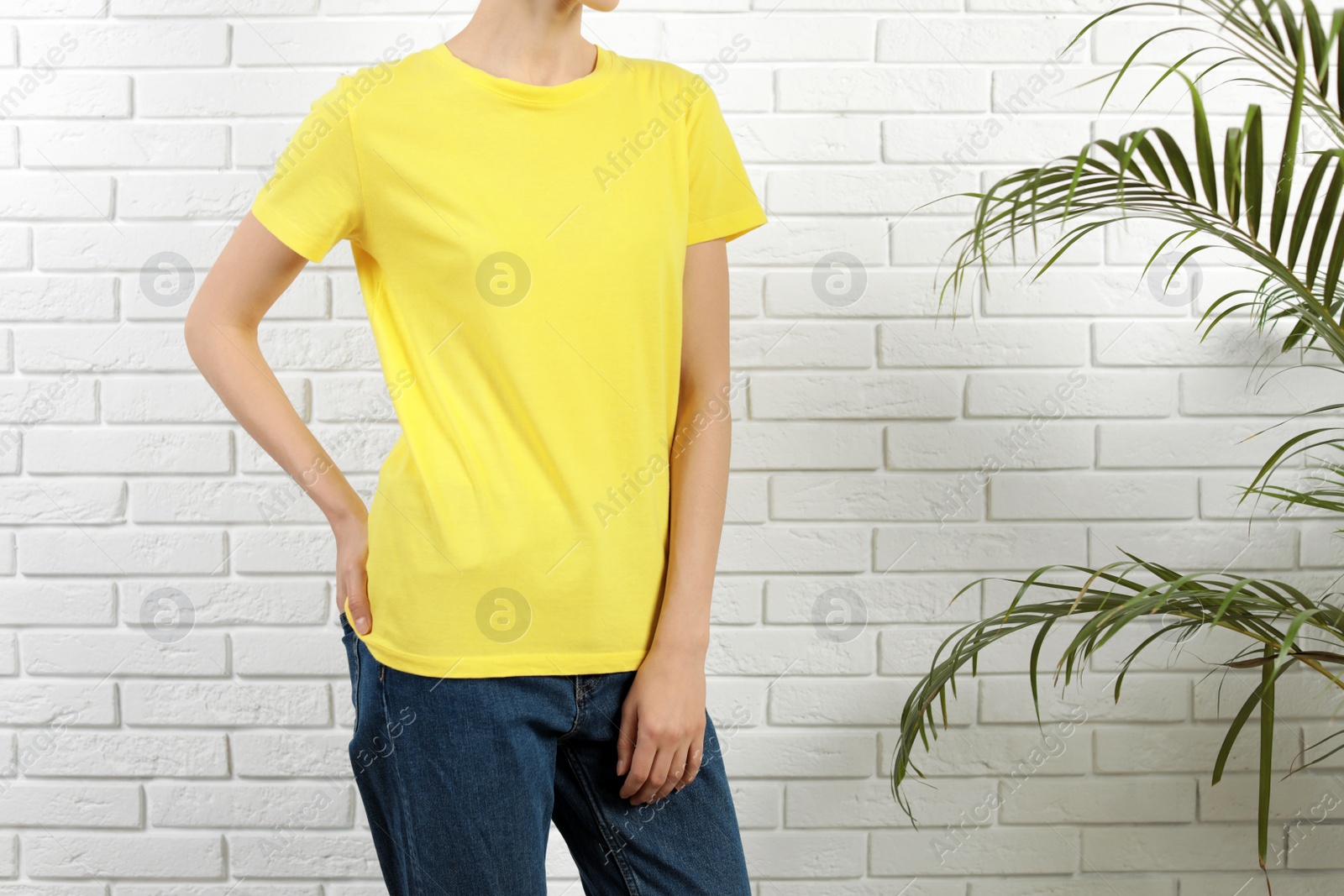 Photo of Woman in bright t-shirt near brick wall. Mock up for design