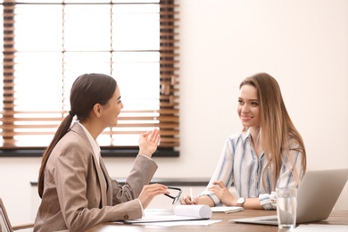 Photo of Female insurance agent consulting young woman in office