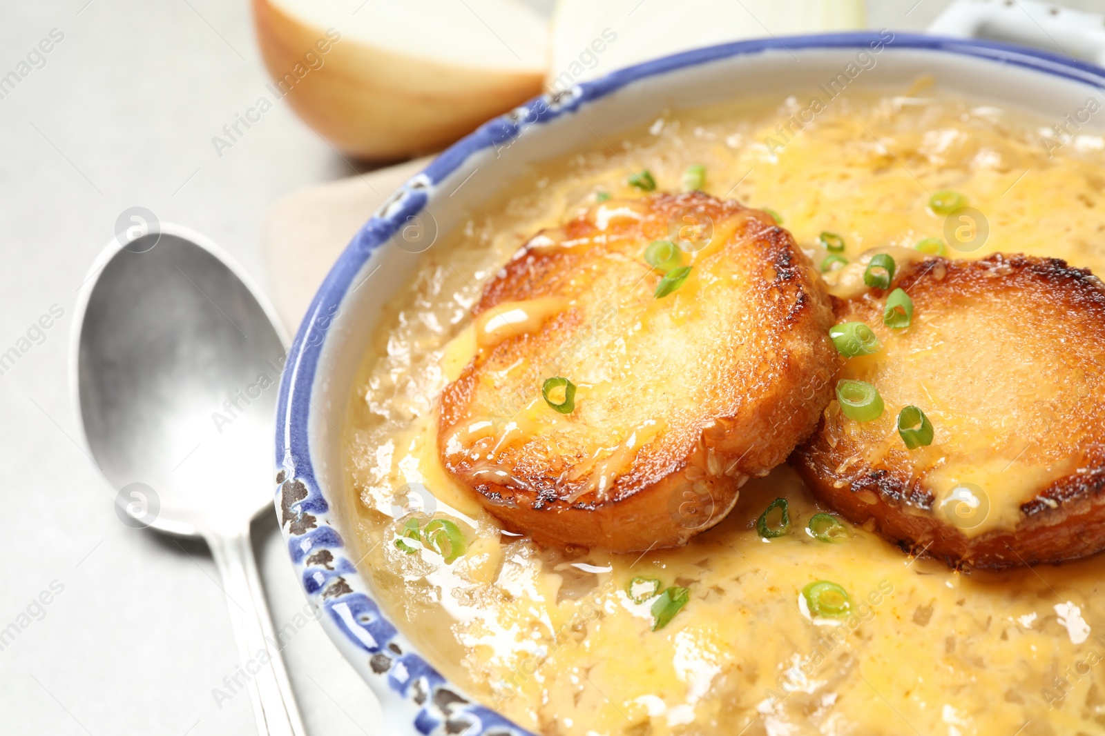 Photo of Tasty homemade french onion soup on table, closeup