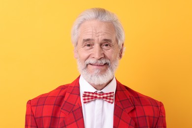 Photo of Portrait of grandpa with stylish red suit and bowtie on yellow background