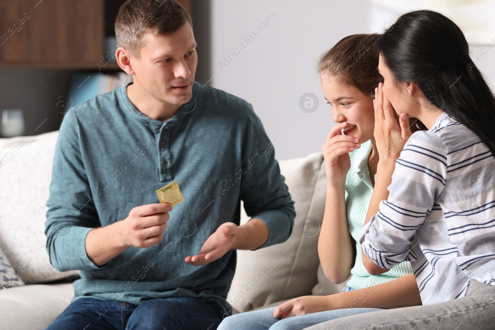 Photo of Parents talking with their teenage daughter about contraception at home. Sex education concept