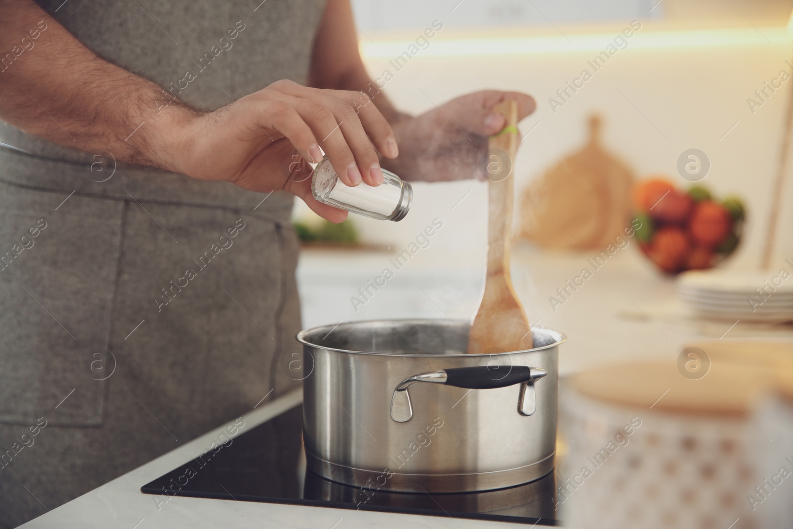 Photo of Man cooking on stove in kitchen, closeup