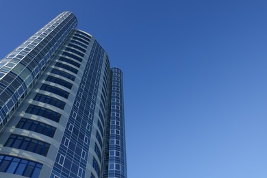 Beautiful skyscraper against blue sky on sunny day, low angle view