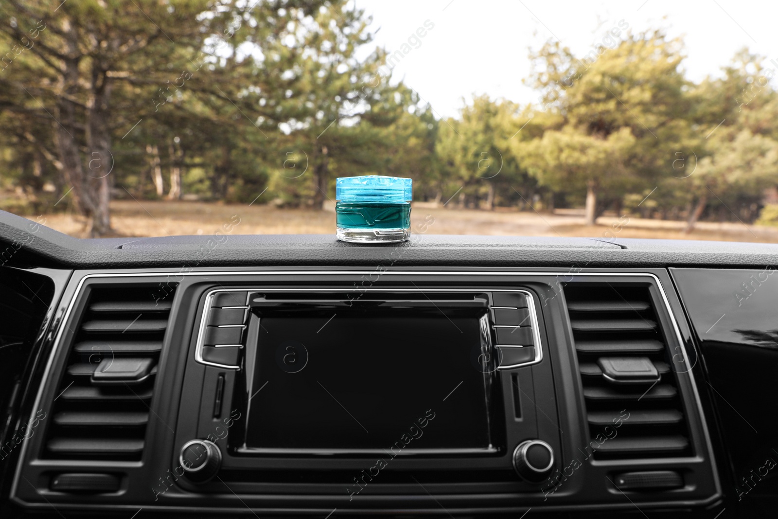 Photo of Stylish air freshener on dashboard in car