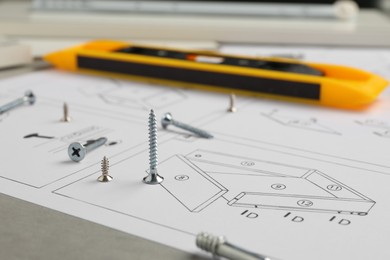 Photo of Furniture assembly plan and different fasteners on light table, closeup