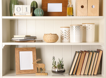 Photo of White shelving unit with books and different decorative elements