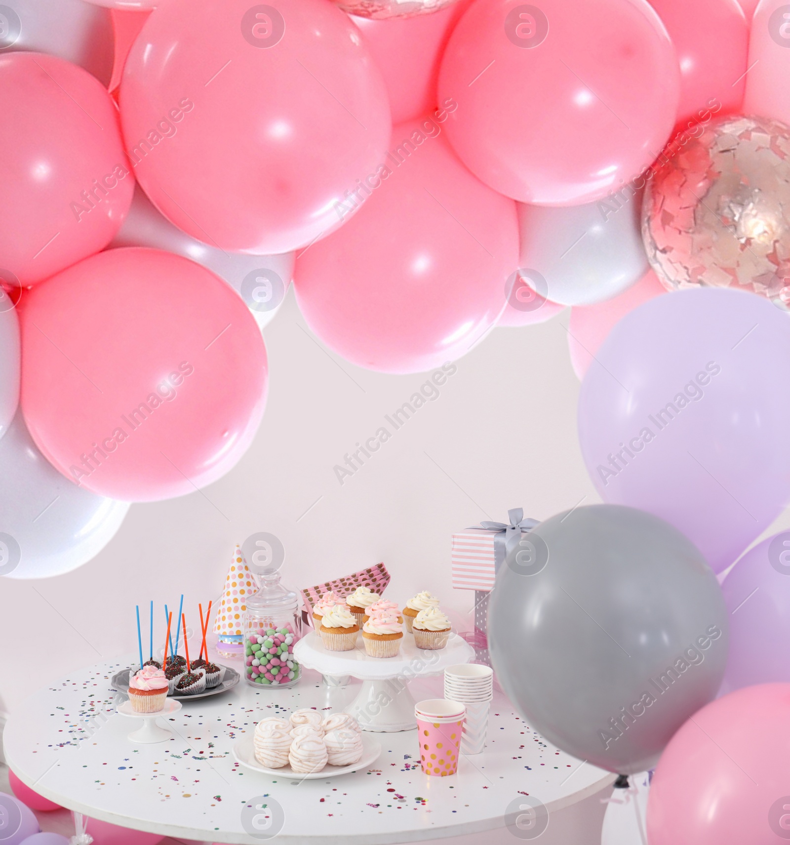 Image of Baby shower party for girl. Tasty treats on table in room decorated with balloons