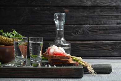 Photo of Cold Russian vodka with snacks on wooden table