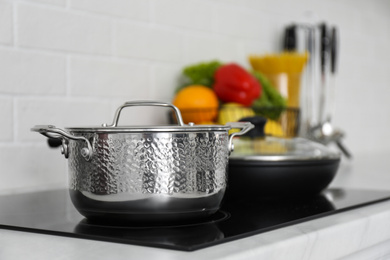 Saucepot and frying pan on induction stove in kitchen