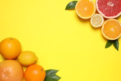 Photo of Different citrus fruits on yellow background, flat lay. Space for text
