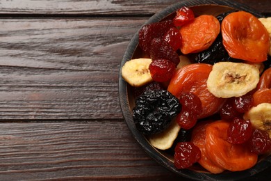 Photo of Mix of delicious dried fruits on wooden table, top view. Space for text