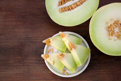 Cut tasty ripe melon on wooden table, flat lay. Space for text