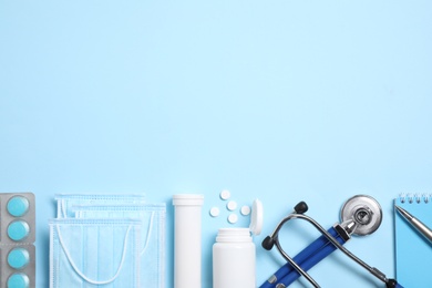 Flat lay composition with medical items on light blue background. Space for text