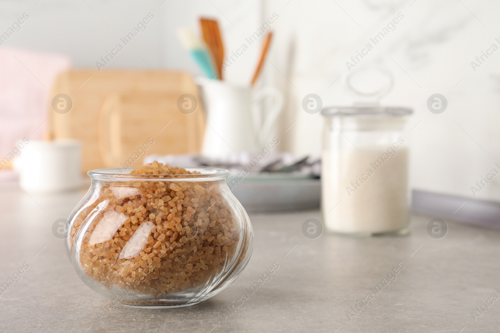 Photo of Glass bowl with brown sugar on grey table