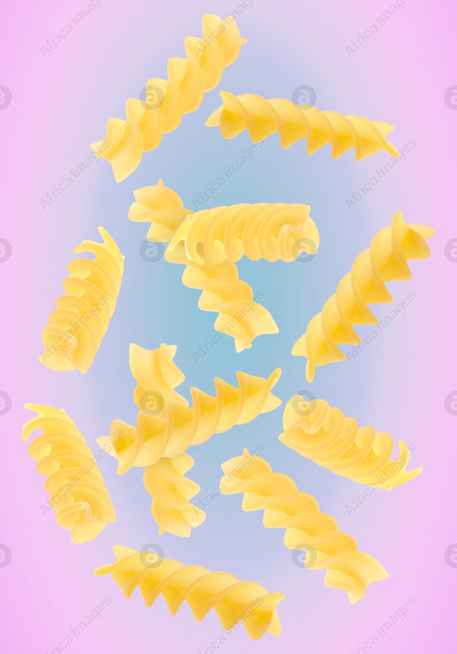 Image of Raw fusilli pasta flying on color background