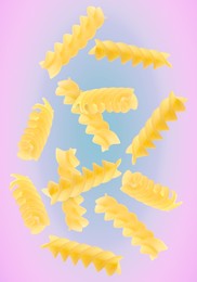 Raw fusilli pasta flying on color background