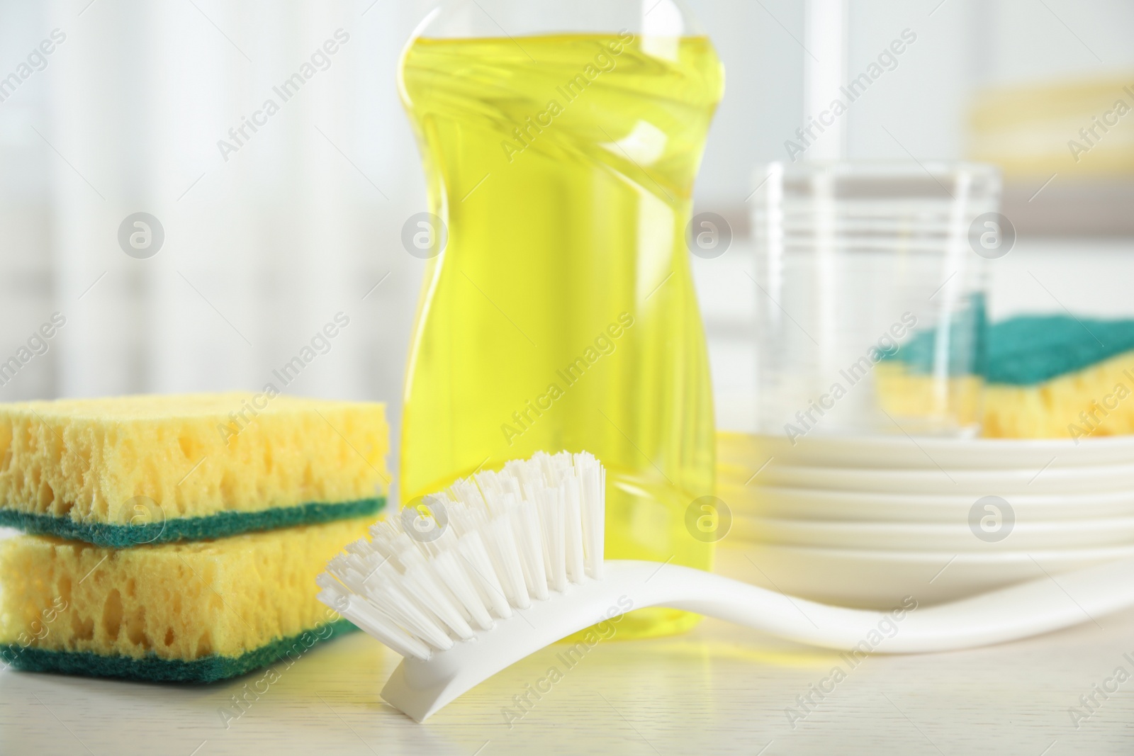Photo of Cleaning supplies for dish washing on table indoors, closeup