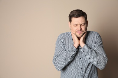 Man suffering from cough on color background. Space for text