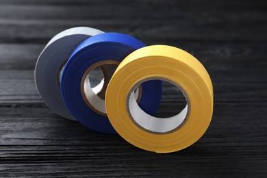 Colorful insulating tapes on black wooden table