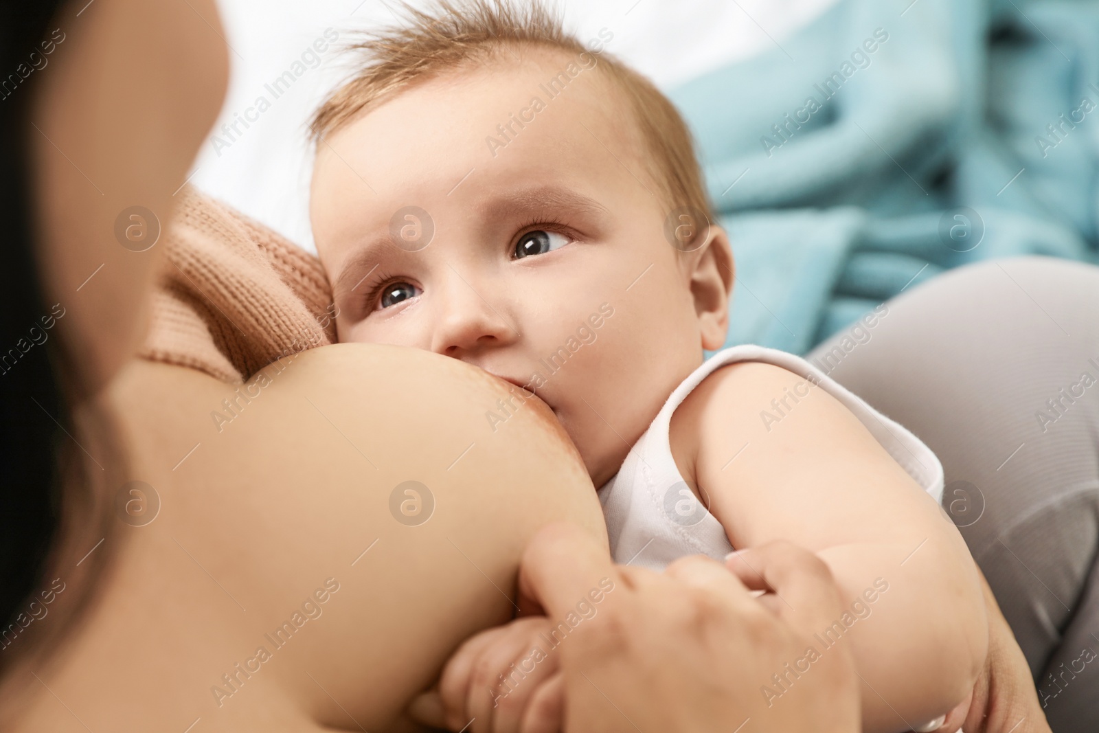 Photo of Woman breastfeeding her little baby on blurred background, above view