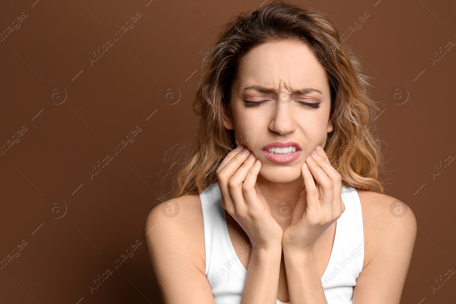 Photo of Young woman suffering from toothache on color background