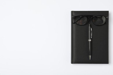 Photo of Notebook, pen and eyeglasses on white background, flat lay with space for text. Teacher's Day